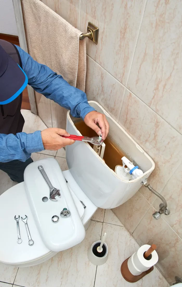 A plumber repairing the toilet,